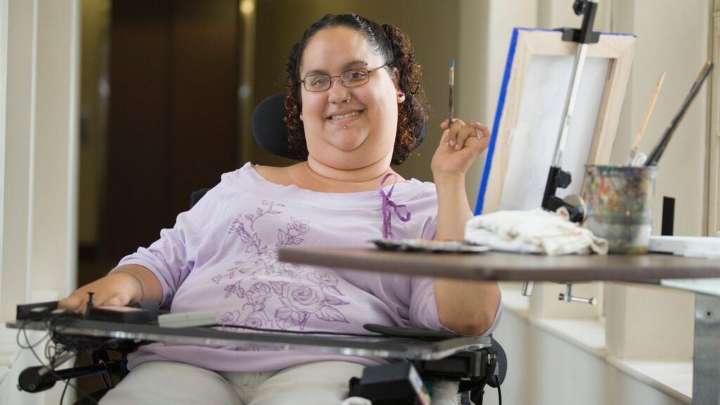 an artist, who uses a wheelchair, at work 